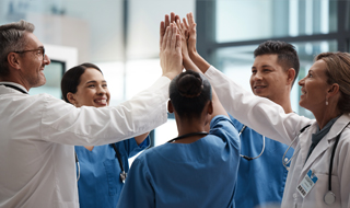 A group of healthcare professionals standing in a circle with their hands raised. photo