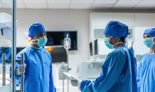 Individuals dressed in blue scrubs and masks, standing together in a hospital setting. photo